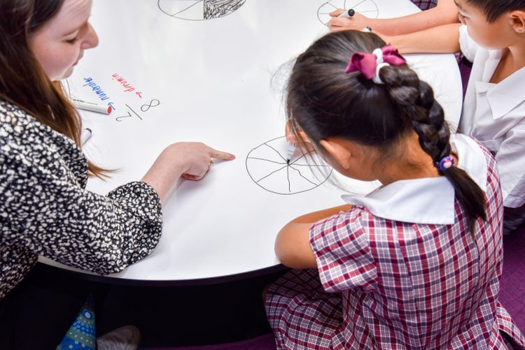 A teacher assisting a student in class