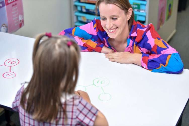 A teacher assisting a student in the classroom